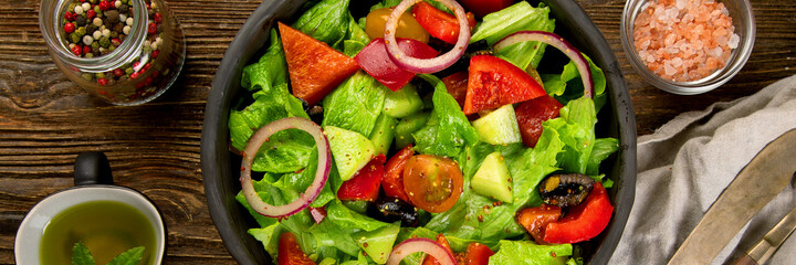 Fresh vegetables salad on wooden background. Healthy eating concept.