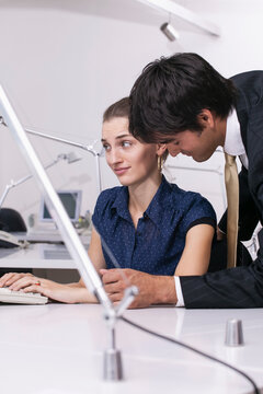 Businessman flirting with disgusted businesswoman in office
