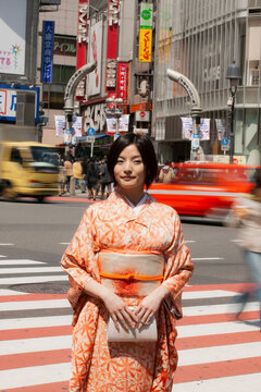 Portrait beautiful young woman in kimono on busy city street, Izu, Japan
