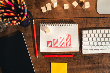 Drawing a graph of growth in a notebook on your desk at home.
