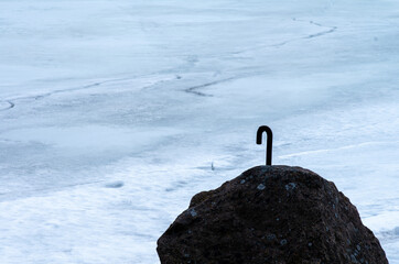 An iron hook attached to a rock by the frozen sea