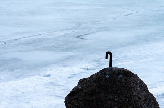 An iron hook attached to a rock by the frozen sea
