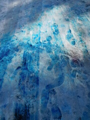abstract background texture of snow painted with blue and red paint with embossed traces of car tires 