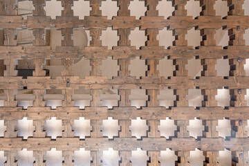 Openwork wooden lattice. Fragment of an ancient wooden gate. Abstract background.