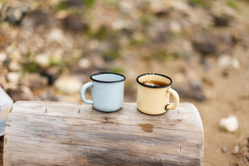 two mugs of tea in the open air. outdoor recreation concept.