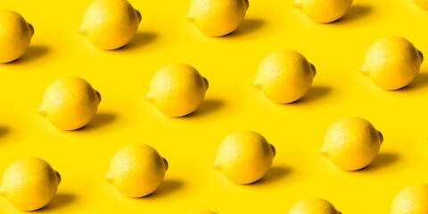 Pattern of ripe lemons on a yellow background. Summer concept.