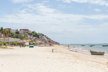 Beach view with fishermen and traditional Angolan boats, in Luanda beach, ghetto as background