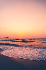Fototapeta premium Tropical beach with smooth wave and sunset sky abstract background.