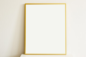 empty minimal style golden vertical frame on white table with white wall on the background