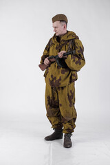 Actor man in an old military uniform and camouflage sniper marksman clothing of a soldier of the...