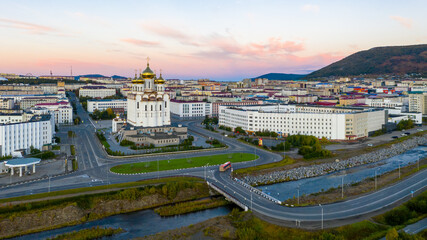 Aerial view of the city of Magadan. Morning city landscape. View of the large Orthodox cathedral, streets, buildings and the bridge over the Magadanka River. Magadan, Magadan region, Russian Far East.