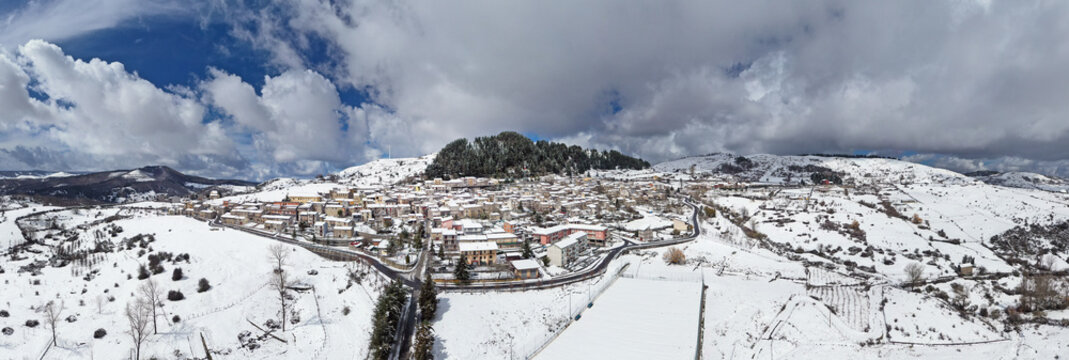 180 degree aerial shot with drone of the small town of Floresta, the highest town in Sicily, in the heart of the Nebrodi. Winter in Floresta. Snow in Sicily. Sicilian winter. View of the snow-covered 