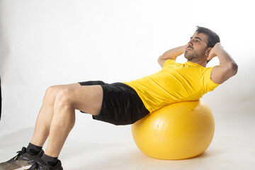 man exercising with fitball on white background