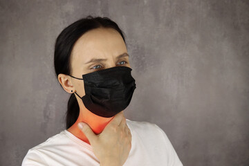 Woman in protective medical mask touches the throat with pain, area of red color