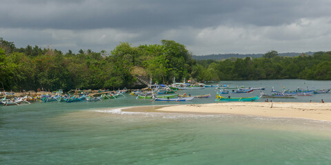 Panorama view of Pero village fishing harbor with wooden outrigger boats and turquoise water, Sumba island, East Nusa Tenggara, Indonesia