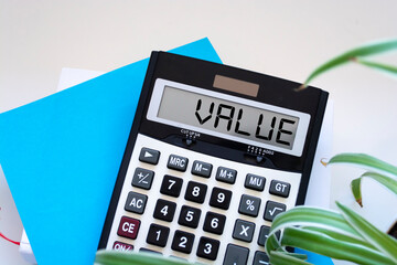 Calculator with text VALUE on Sticky. Business, finance conceptual.