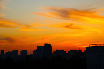 Obraz na płótnie Canvas Beautiful bright sunset over the city on a summer day.