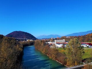 Fototapeta na wymiar Sava river and the town of Kranj in Gorenjska, Slovenia and an industrial district in front and hill Smarjetna gora in the side