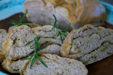 Beautiful freshly baked homemade bread with a sprig of rosemary.