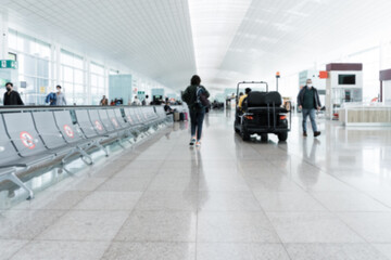 Blurred tourist passengers wearing safety masks inside airport during coronavirus pandemic outbreak...