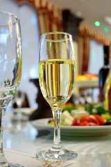 a glass of champagne or white wine on a festive table, close-up photo