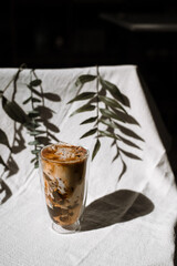 glass of coffee with milk on a white canvas