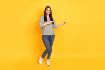 Fototapeta na wymiar Full length body size view of attractive cheerful girl demonstrating new novelty copy space ad isolated over bright yellow color background