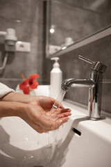 Close up of a girl washes her hands in the bathroom.