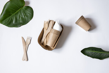 Composition with a set of disposable paper utensils and natural leaves copy space.