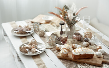 Obraz na płótnie Canvas Easter table setting with freshly baked pastries and decor details.