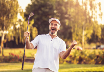 Happy successful man on golf field. - 423160447