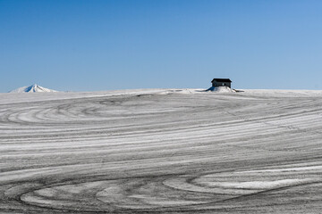 Fototapeta premium 3月の美瑛町 融雪剤がまかれた丘と小屋のある風景 