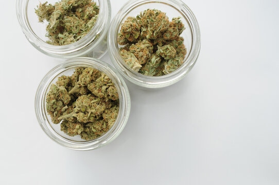 Marijuana buds storage. Medicinal cannabis flowering on white background, isolated, top view. Hemp recreation, medical usage, pastime.
