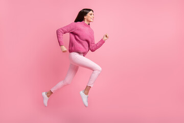 Fototapeta na wymiar Full size profile photo of brunette nice girl jump run wear pink sweater pants sneakers isolated on crimson background