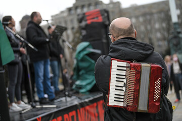 The old rare red accordion hanging on back of an accordion musician. Buttons and keyboard close up...