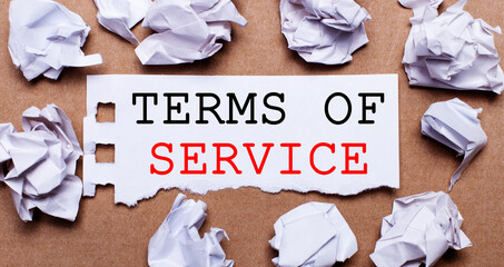 TERMS OF SERVICE written on white paper on a light brown background.