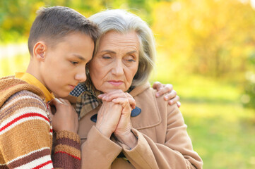 grandmother  and grandson hugging  in park