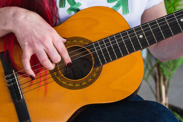 Crop woman playing Spanish guitar