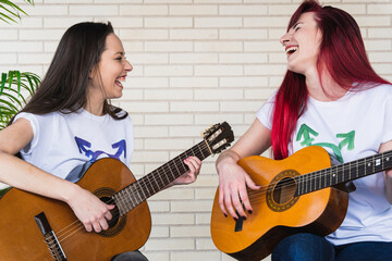 Excited female guitarists laughing together