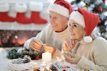 Portrait of happy senior couple preparing for Christmas at home