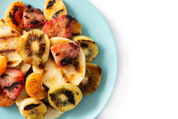 GRILLED FRUIT on a blue plate isolated on white background. Top view. Copy space