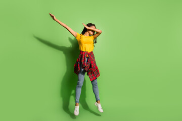 Full length photo of cute pretty dark skin lady dressed yellow t-shirt jumping dancing dab isolated green color background