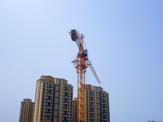 The tower crane on the construction site is busy working