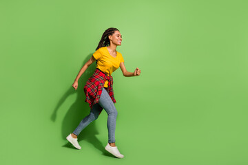 Full length body size view of lovely cheerful girl jumping running fast having fun isolated over bright green color background