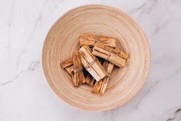 Palo Santo tree sticks in wooden bowl - holy incense tree from Latin America. Meditation, mental health and personal fulfilment concept, aromatherapy. Selective focus