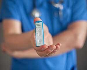 The doctor holds a negative antigen test Covid-19 in his hand 