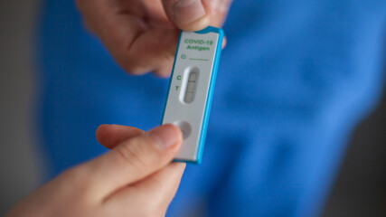 hands holding positive antigen test Covid-19, doctor and patient