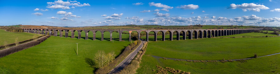 Fototapeta premium A panorama aerial view of the 82 arches of the Welland Valley viaduct on a bright sunny spring day in the UK