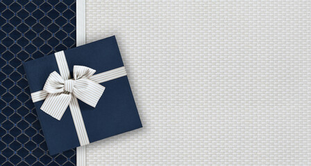 Gift card with gift box with ribbon and bow isolated on elegant blue and gray fabrics background,...
