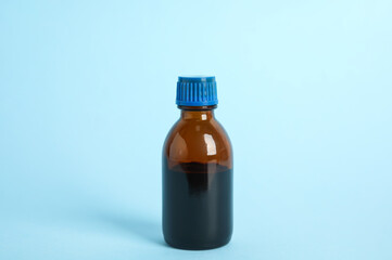 Bottle of medical iodine on light blue background